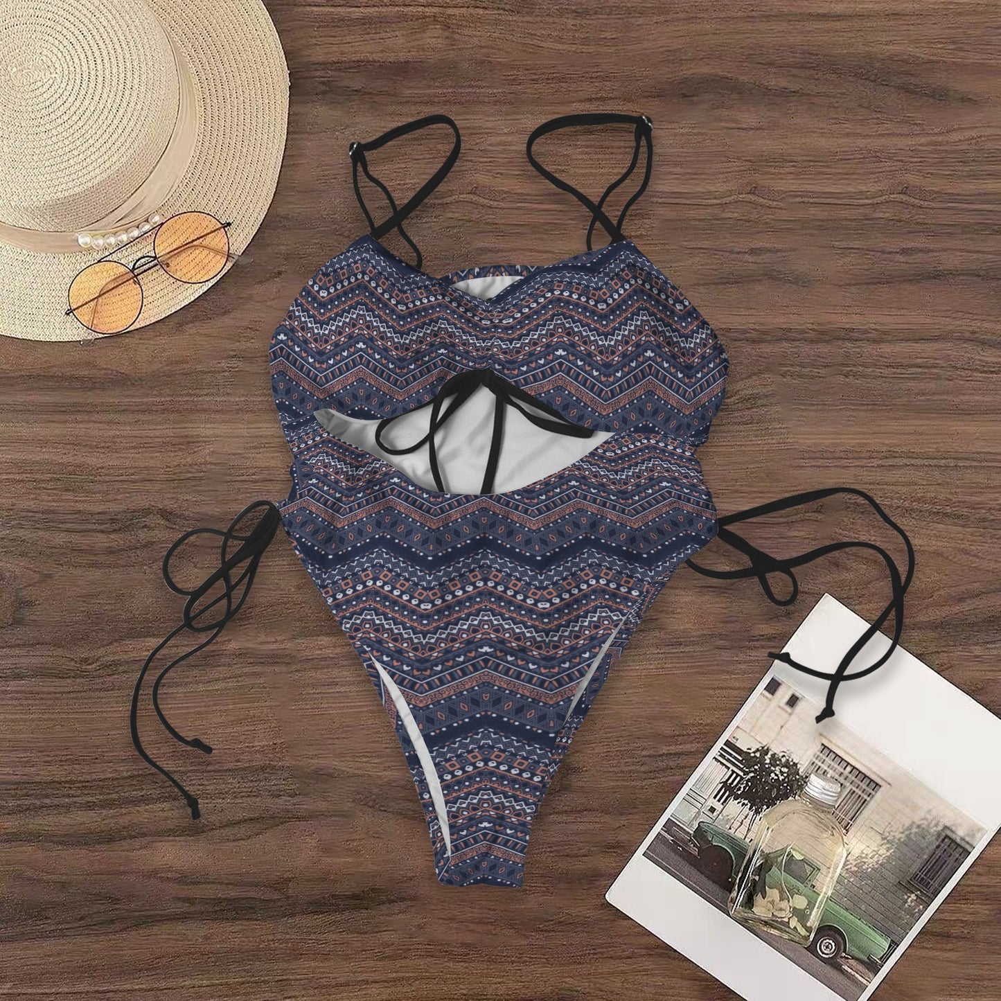 Flat lay of boho cutout one-piece swimsuit with geometric pattern and tie details