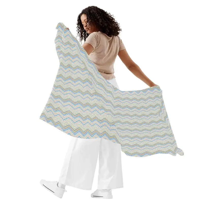 Wavy patterned shawl held by a person with curly hair showcasing a blue boho print