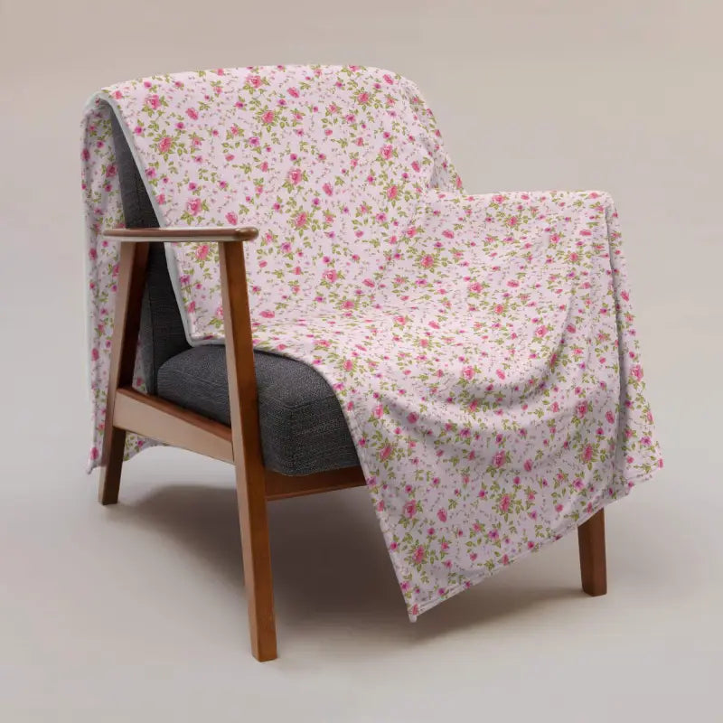 Cozy wooden armchair draped in a warm rose floral sherpa throw for style and comfort