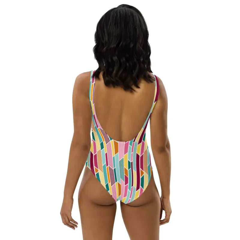Colorful striped geometric print one-piece worn by a dark-haired person from behind