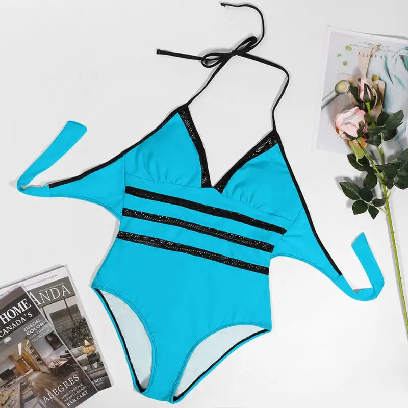 Bright blue one-piece swimsuit with black straps and striped details for stylish summer fun