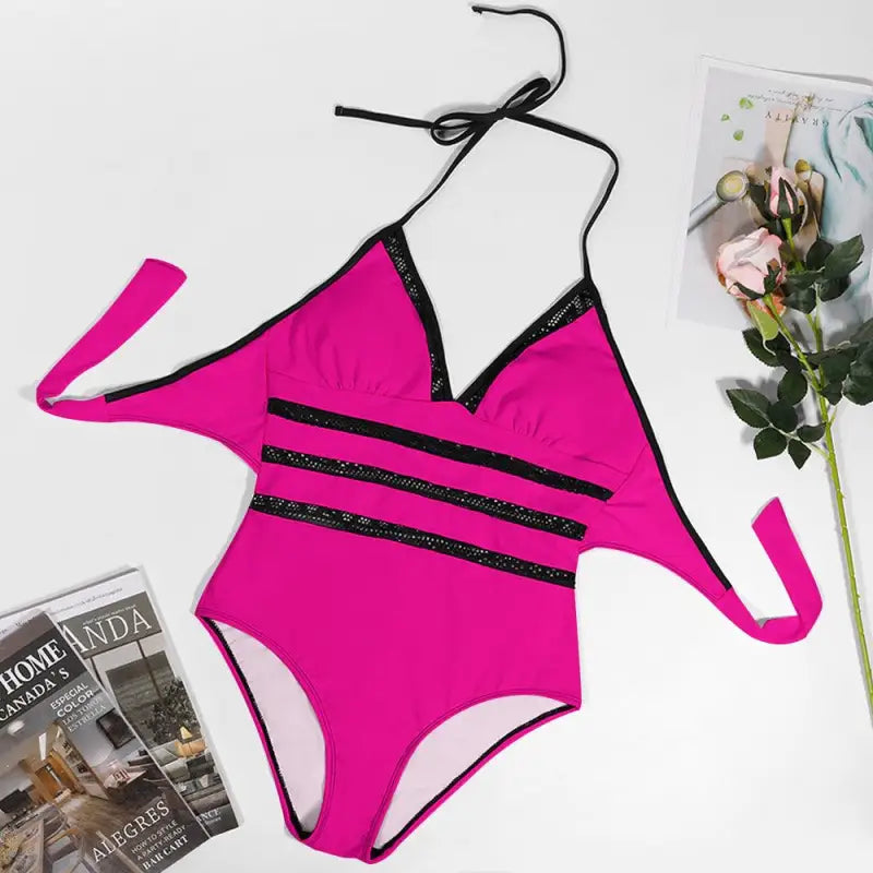 Bright pink one-piece swimsuit with black straps and vibrant lace inset tie design