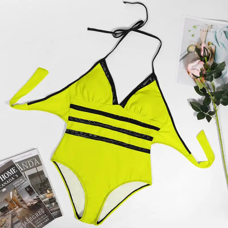 Neon yellow one-piece swimsuit with black straps and stripes, perfect for vibrant lace inset fun