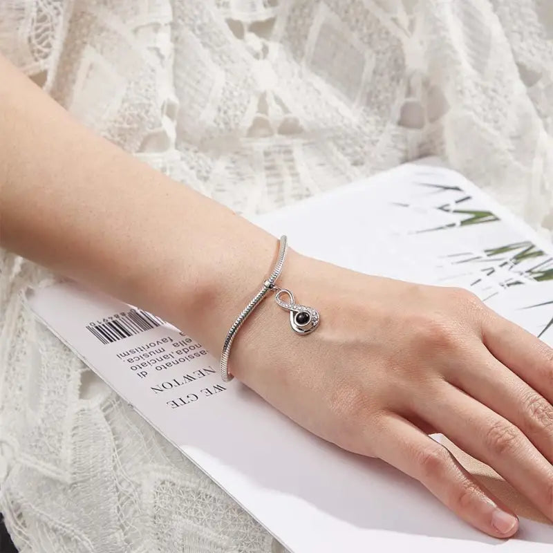 Silver bracelet featuring an Infinite Love Pendant with a cool photo projection charm