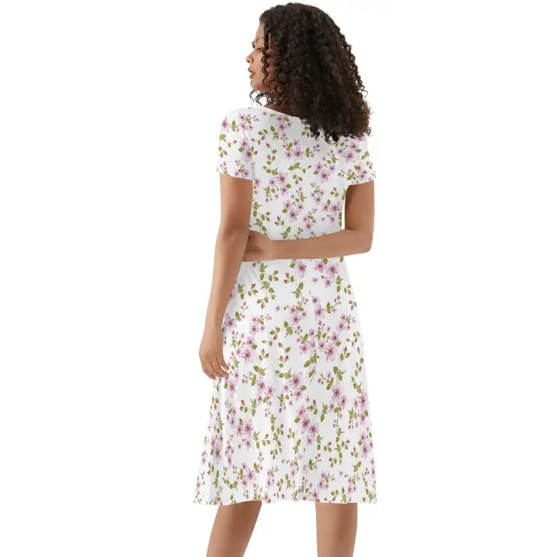 Woman in a purple floral summer dress with short sleeves, looking like a garden party