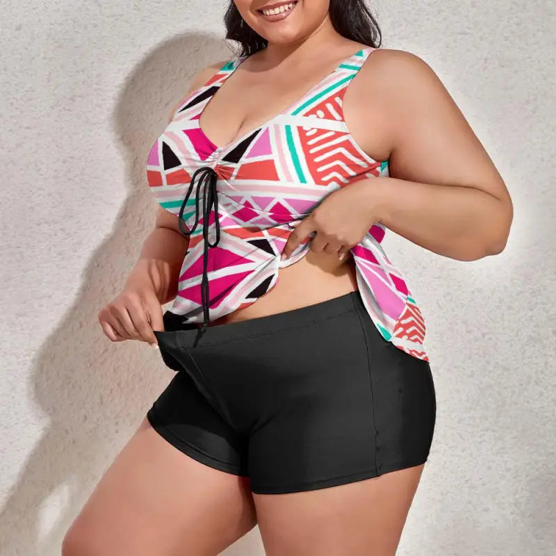 Colorful abstract print tankini top paired with black swim shorts for fun beach vibes