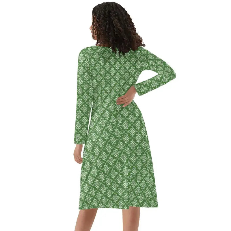 Person with curly dark hair sports a womens green damask long sleeve ruffle dress