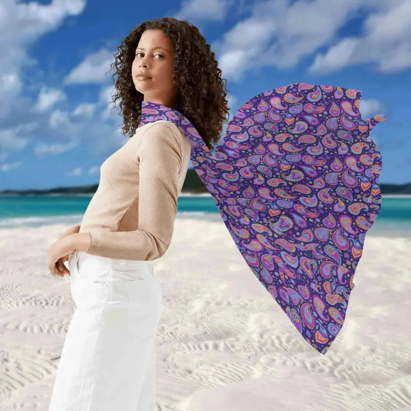 Woman in beige sweater and white pants flaunts a Women’s Purple Paisley Sarong on the beach