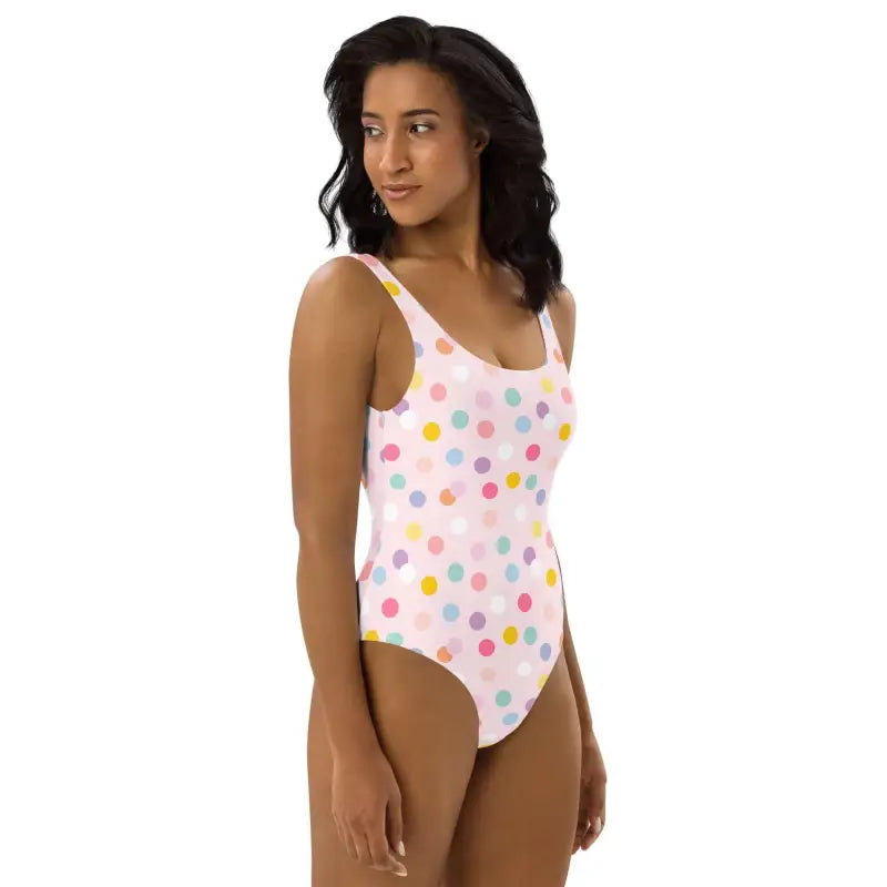 Fun pink polka dot one-piece swimsuit with colorful dots on a white background