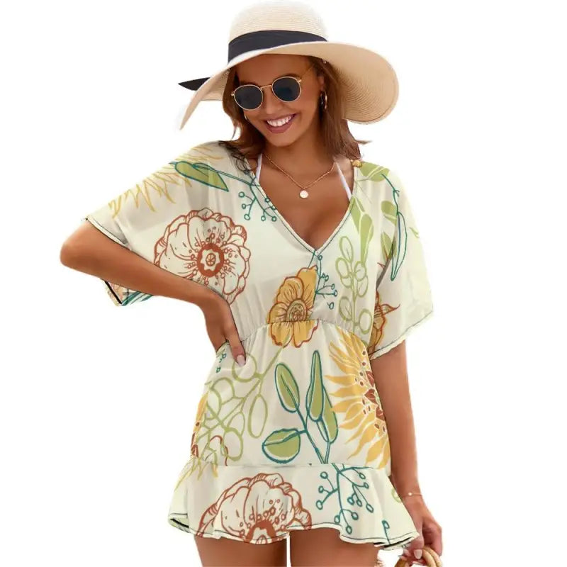 Ladies yellow floral beach coverup paired with a sun hat and stylish sunglasses