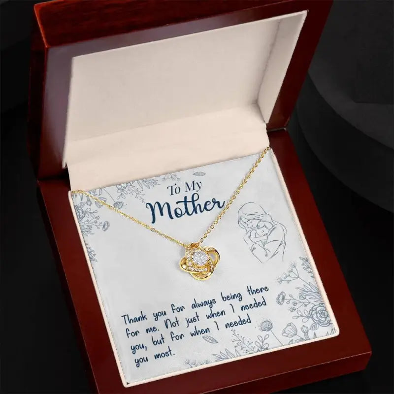 Gold heart-shaped pendant in a red box, perfect for Mom’s Dazzling Love Knot Necklace