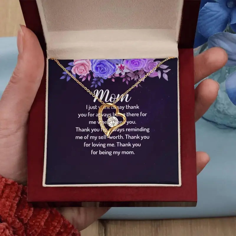 Mom’s Forever Love Heart Necklace in a gift box with blooms and a yellow gold finish
