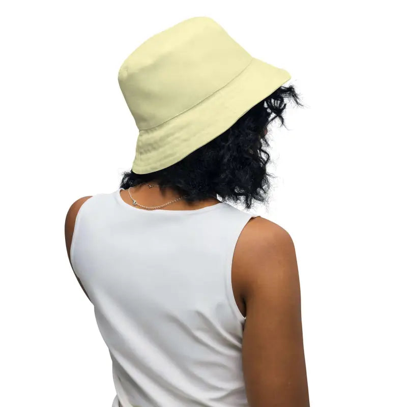 Beige floral reversible bucket hat on a person with curly dark hair
