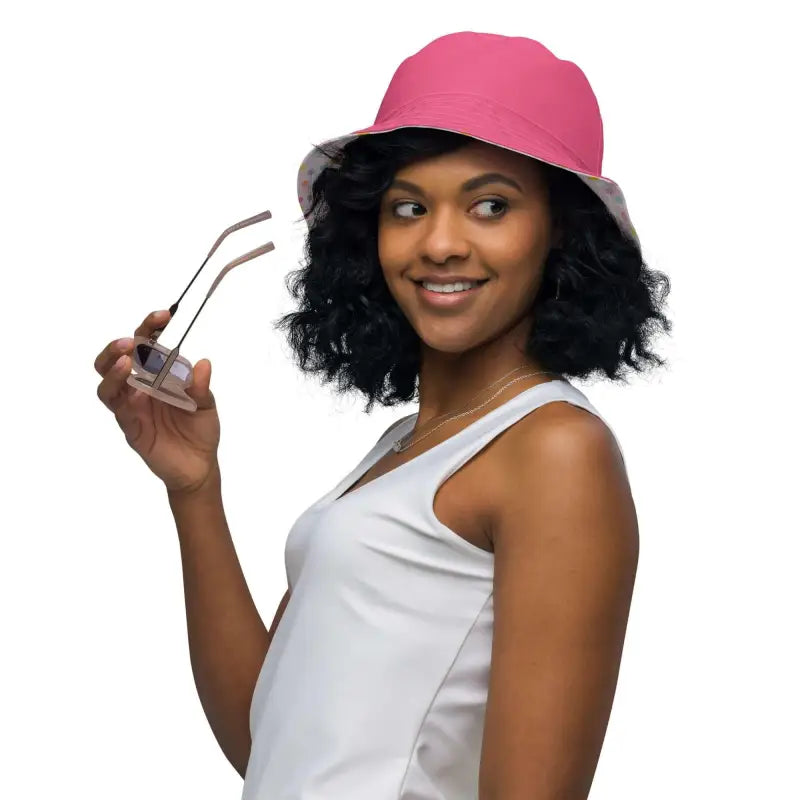Woman rocking a polka dot reversible bucket hat and holding trendy sunglasses