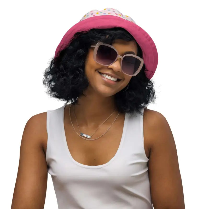 Woman rocking a polka dot reversible bucket hat with a bright pink vibe and cool shades