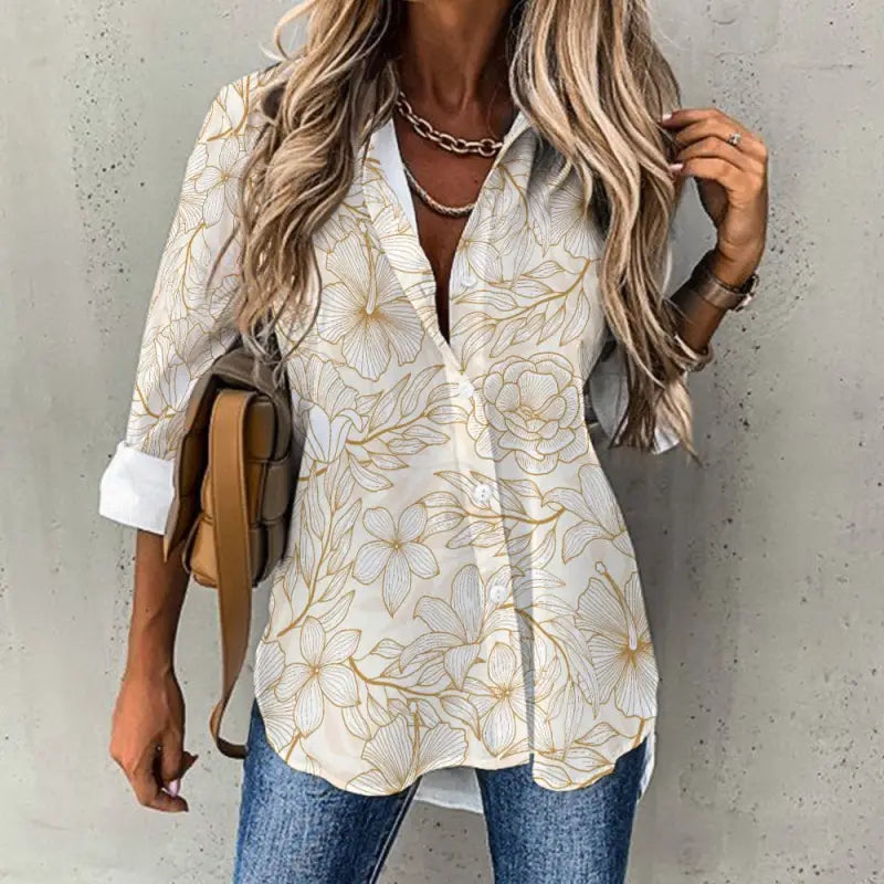 Women’s gold floral print blouse with rolled sleeves styled over jeans for a chic look