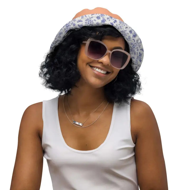 Smiling person rocking a Solid Peach Reversible Bucket Hat with a floral vibe