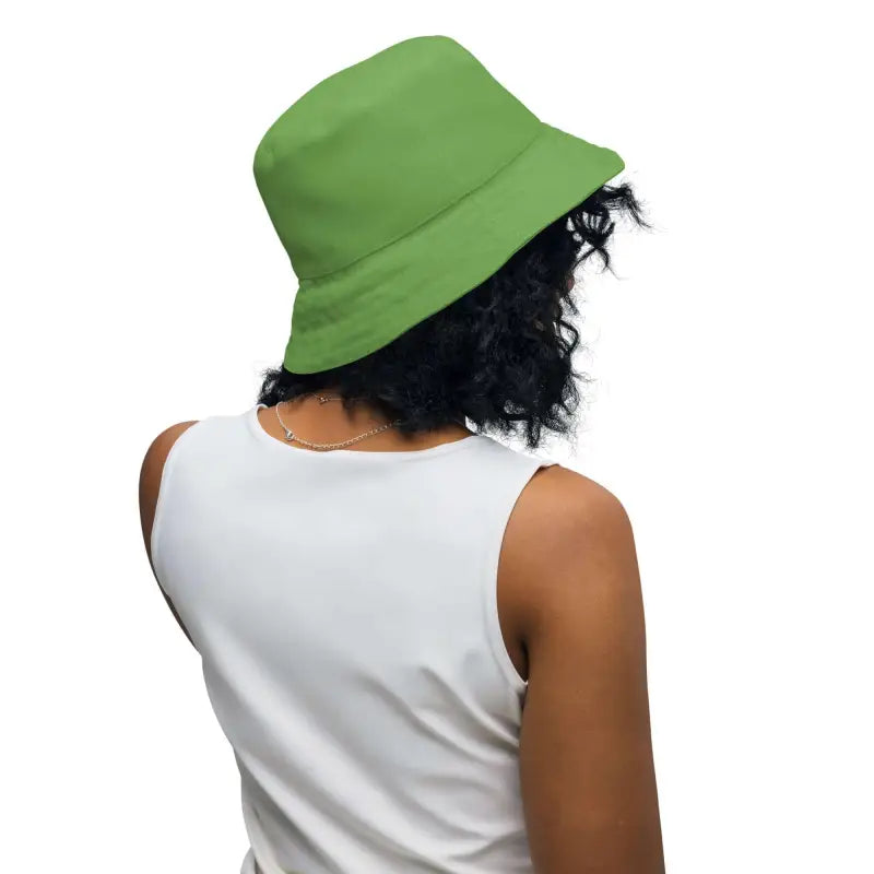 Person with curly hair rocking a bright green rose floral print reversible bucket hat