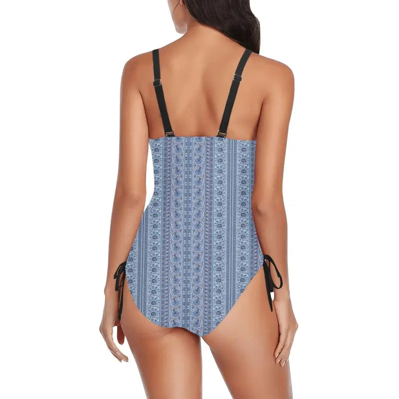 Blue print one-piece swimsuit with black straps and side ties, perfect for a pool party