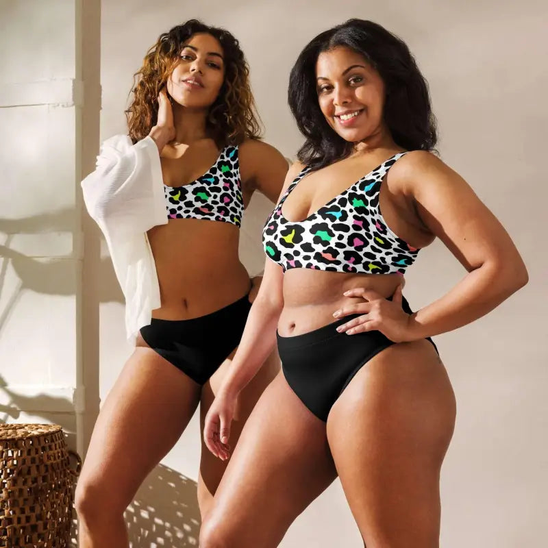 Two women rock colorful leopard print high-waisted bikinis, ready for summer fun