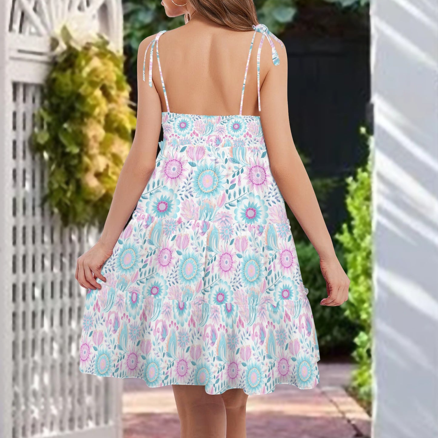 Back view of pastel floral spaghetti strap tiered mini dress with flowy silhouette