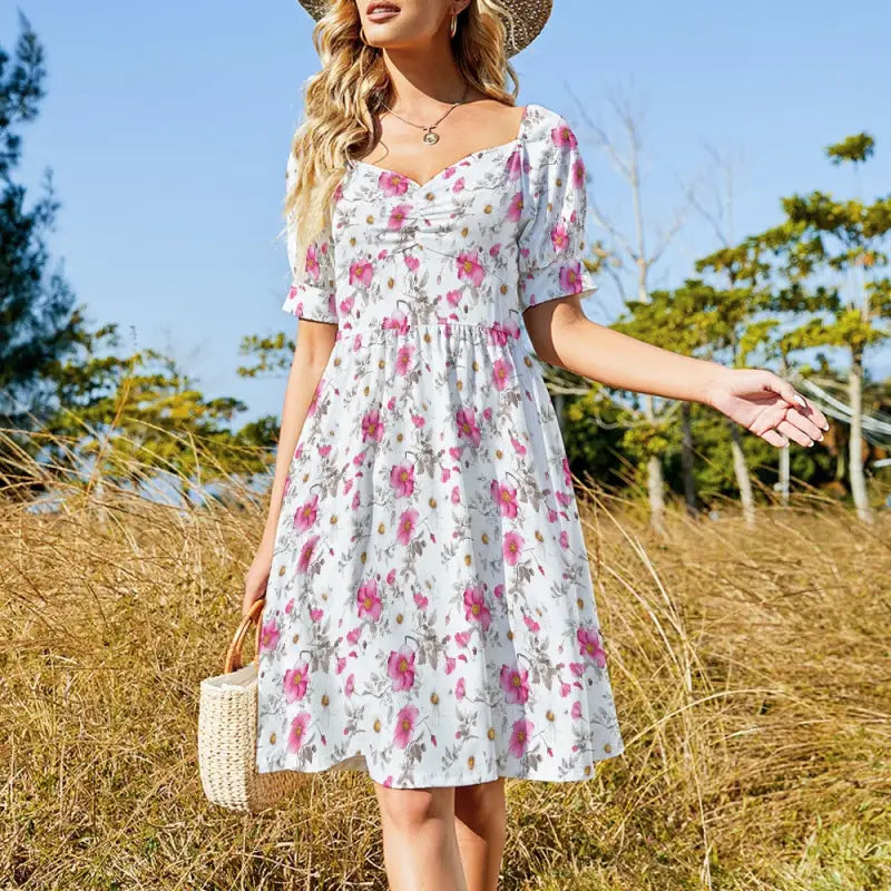 Cottagecore floral A-line dress with sweetheart neckline styled with straw hat and woven handbag