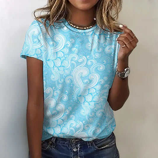 Front view of turquoise swirl print 100% cotton women’s T-shirt styled with jeans.