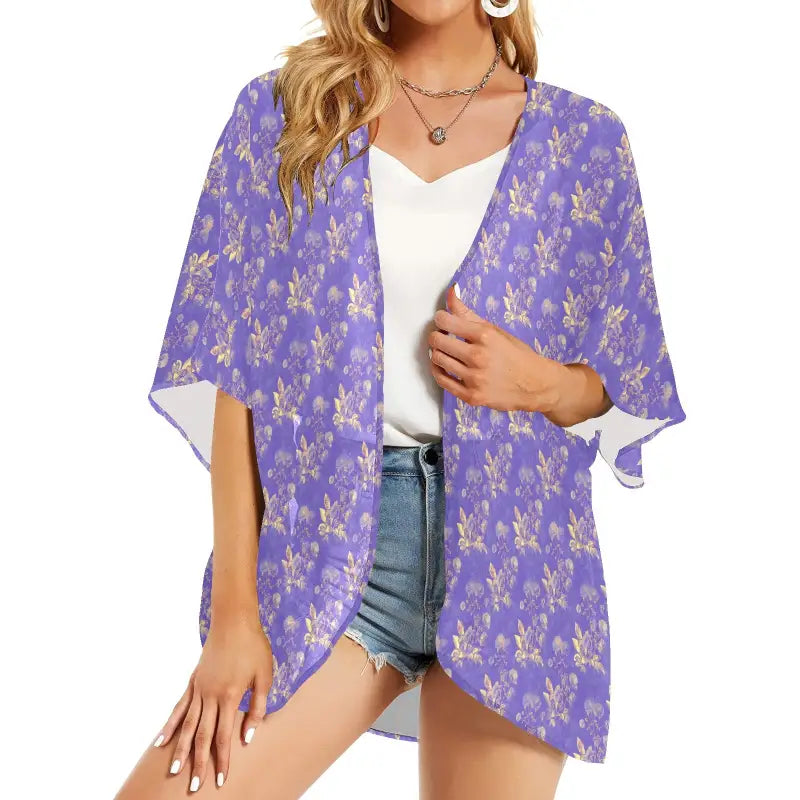 Purple floral chiffon kimono cardigan worn open over white top and denim shorts
