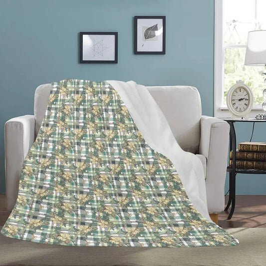 Cozy green plaid floral ultra-soft micro fleece blanket on a white couch