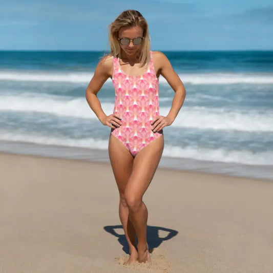 Woman in a pink geometric print one-piece swimsuit enjoying the beach vibes