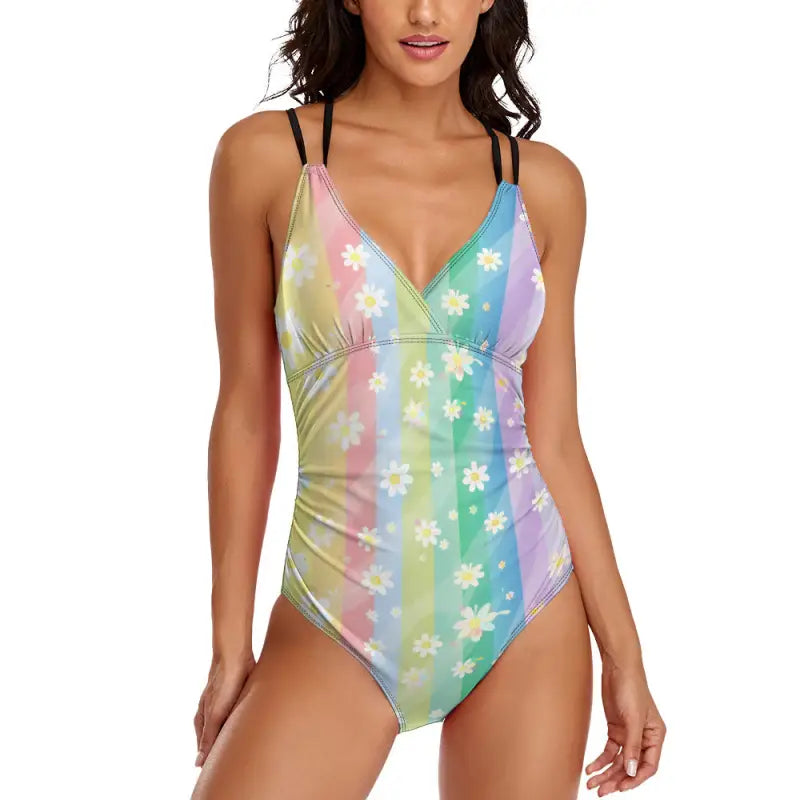 Pastel rainbow one-piece with daisy prints and black straps, perfect for summer fun