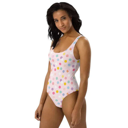 Fun pink polka dot one-piece swimsuit with colorful dots on a light background