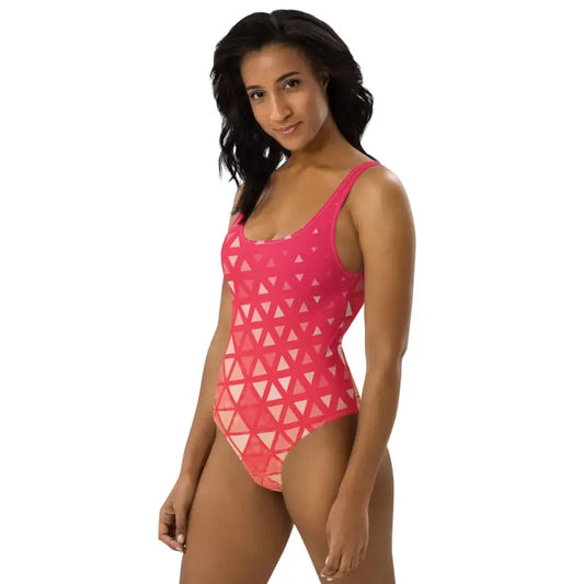 Cute pink one-piece swimsuit with orange geometric print for a stylish beach look