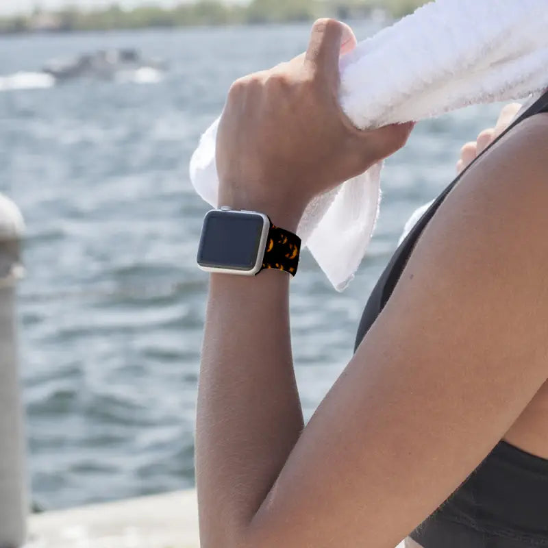 Person with Halloween Apple Smartwatch Band by the water, perfect for the festive season