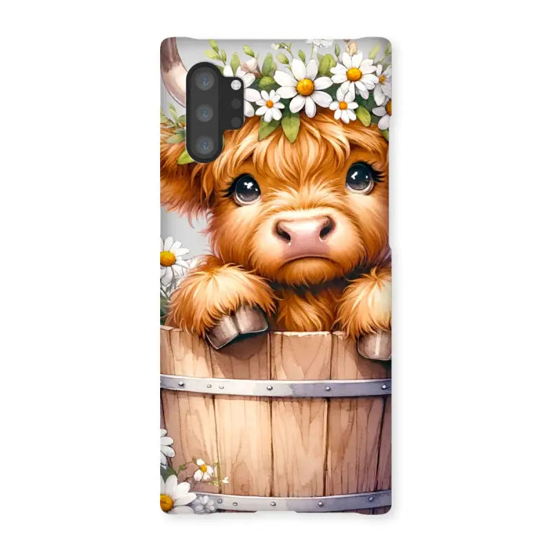 Cute Highland Cow calf with flower crown peeking from a barrel on Highland Cow Snap