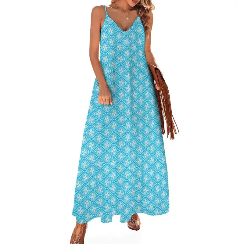 Turquoise flowing sleeveless boho maxi dress with white floral pattern and thin straps