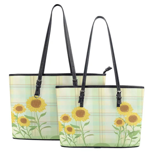 Two matching sunflower shoulder totes with adjustable straps on a green background